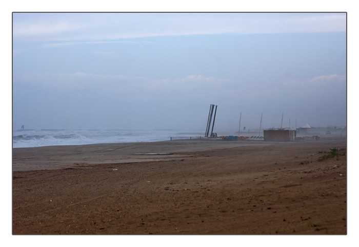 Blick auf das aufwühlende Meer und den düsteren Strand